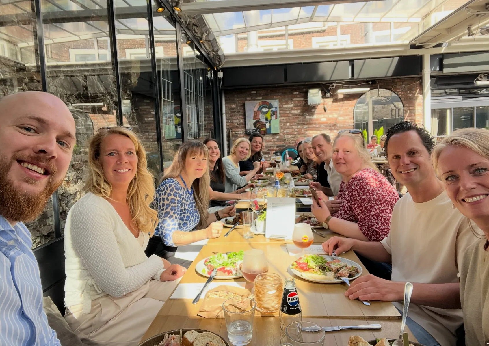 Groepsfoto van het team aan de lunchtafel bij Picasso in Den Bosch