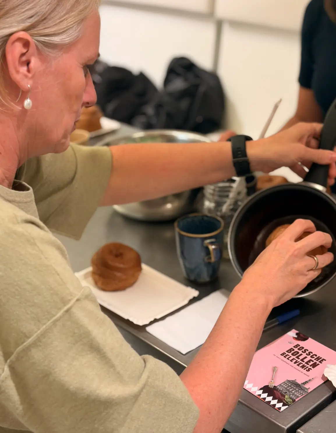 Een Bossche bol wordt gedipt in pure chocolade