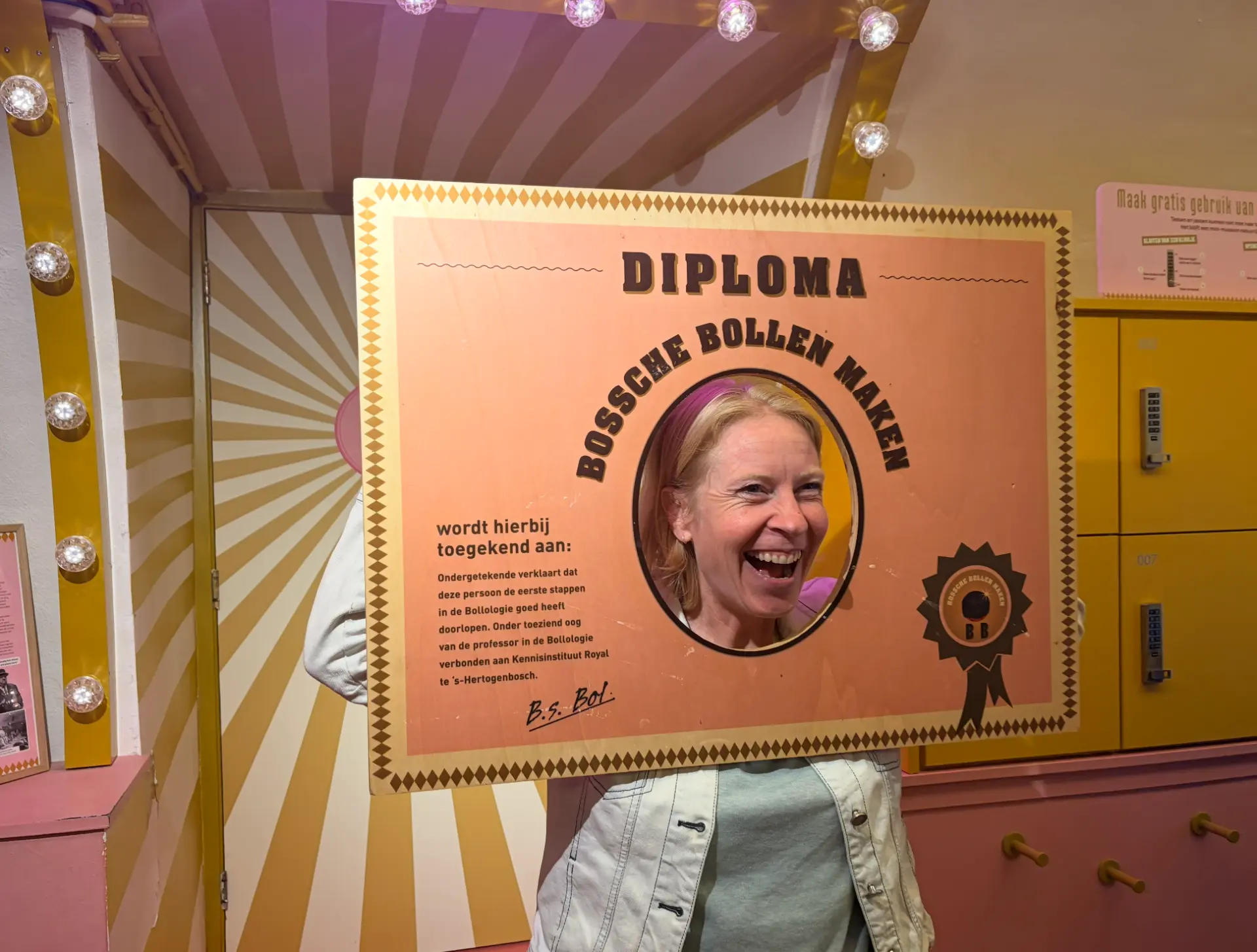 Een deelnemer lachend achter het diploma Bossche bollen maken
