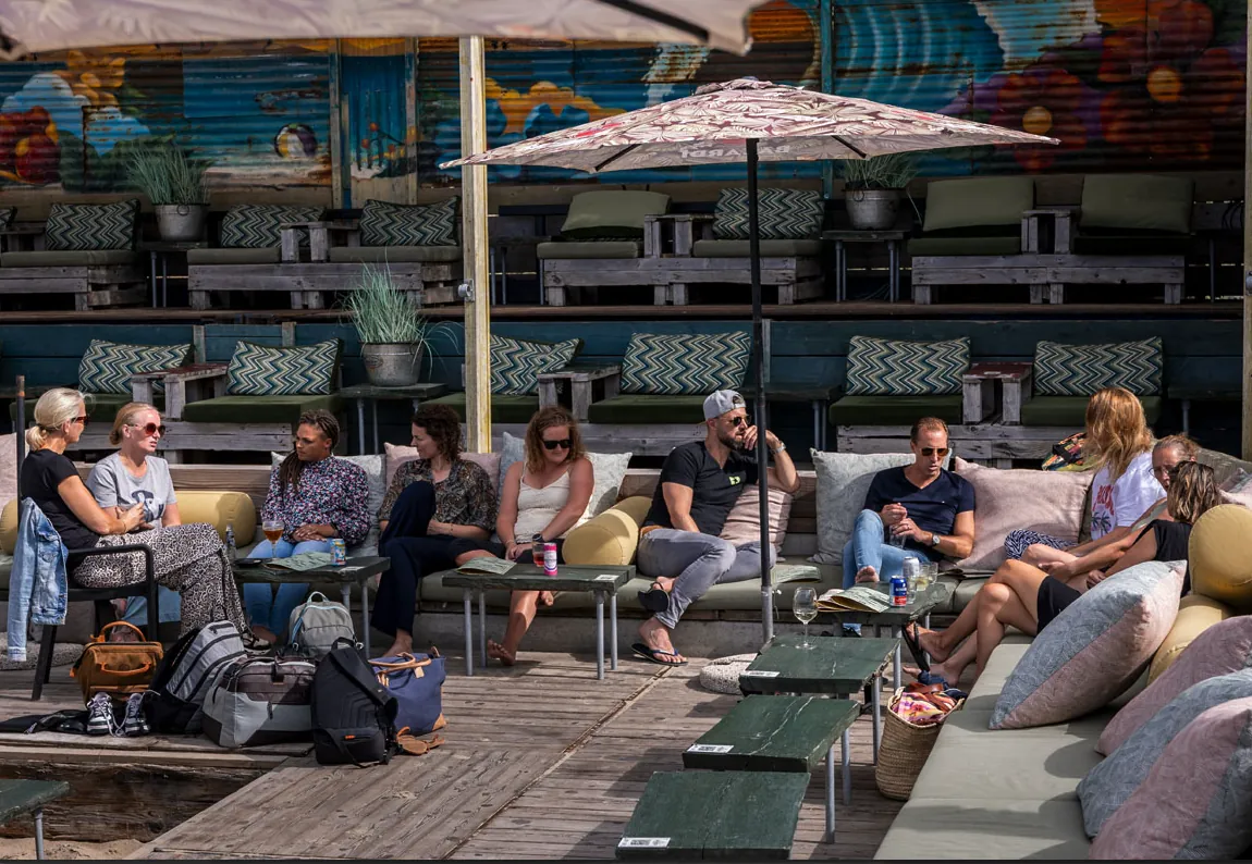 Het team ontspant samen op het terras na het surfen