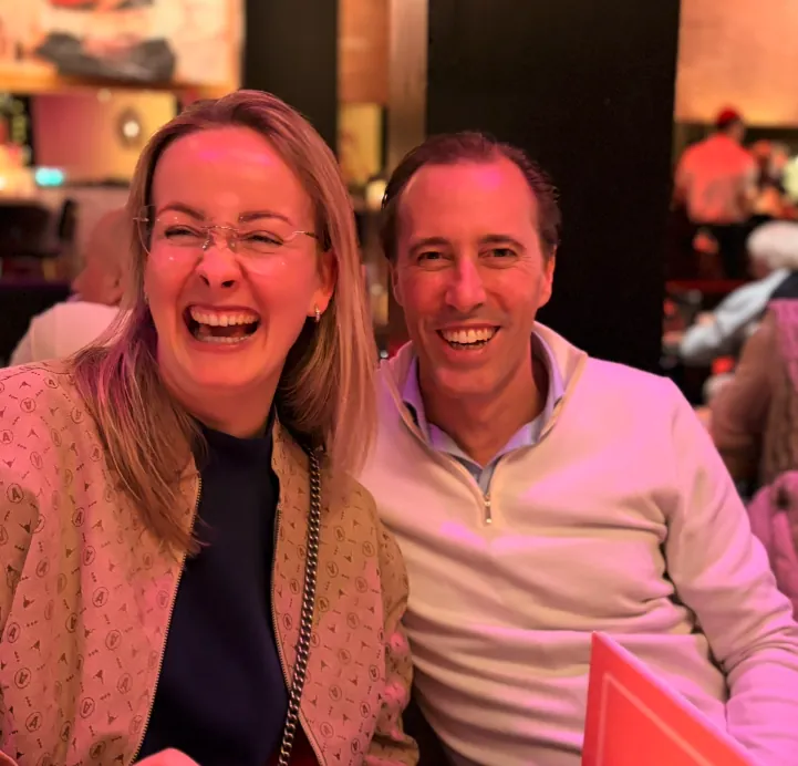 Twee teamleden lachen samen bij het diner in Nijmegen
